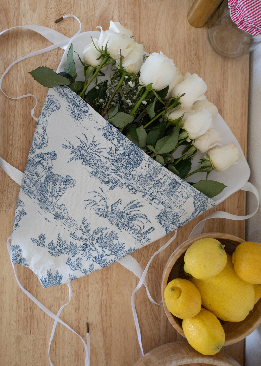 Fresh Flower tote bag with roses and lemons on a wooden counter, accompanied by a sewing pattern for a flower tote.